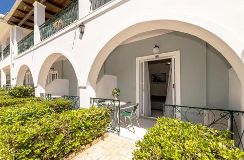 a balcony of a building with a table and chairs at Sofia's Hotel in Kalamaki