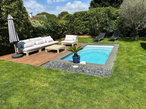 - une piscine avec un canapé, des chaises et un parasol dans l'établissement Villa Les Roses, à Marseille