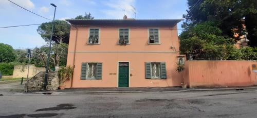 a pink house with a green door on a street at La Casa Del Podestà 65 in Florence