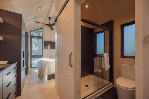 a bathroom with a shower and a toilet and a bed at Black Prong Resort in Bronson