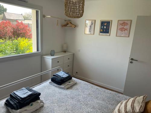 une chambre avec deux sacs sur un lit avec une fenêtre dans l'établissement l Orbinicaise, à Trémuson