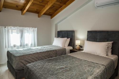 two beds sitting next to each other in a room at Zante way villas in Alikanas