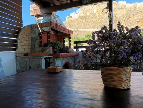 a table with a vase of purple flowers on it at Sofia Skyros in Skiros