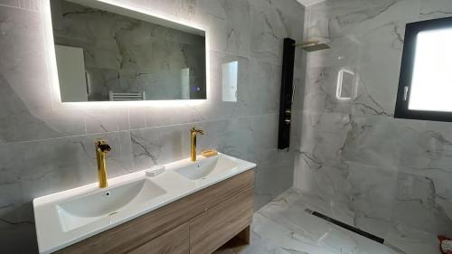 a white bathroom with two sinks and a mirror at Maison moderne avec Piscine in Creysse
