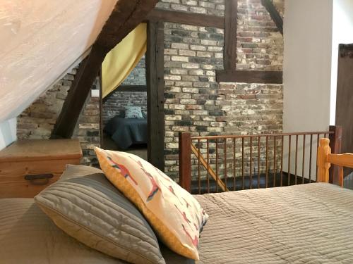 une chambre avec un lit et un mur de briques dans l'établissement Tournesol Gîte Charmant en Pleine Nature pour 6 Personnes, à Vireux-Wallerand
