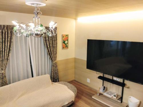 a living room with a large flat screen tv at Somnus豊田 ペットOK 最大宿泊人数12名!1棟貸切の宿 in Toyota