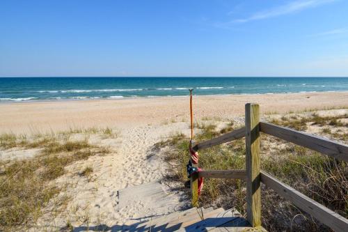 a beach with a wooden fence and the ocean at Sounds Beachy in North Topsail Beach