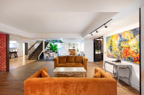 a living room with orange furniture and a painting on the wall at Hotel Presidente in San José