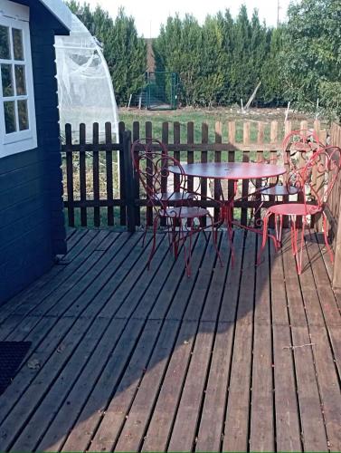 un patio avec une table et des chaises sur une terrasse dans l'établissement loue chalet calme tout équipé, à Madaillan