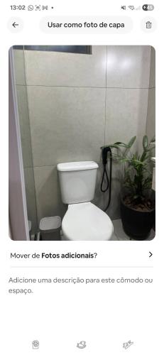 a bathroom with a toilet and a plant at Cantinho do Aconchego in Campo Grande