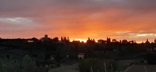 a sunset over a city with trees and buildings at La Casa Del Podestà 65 in Florence