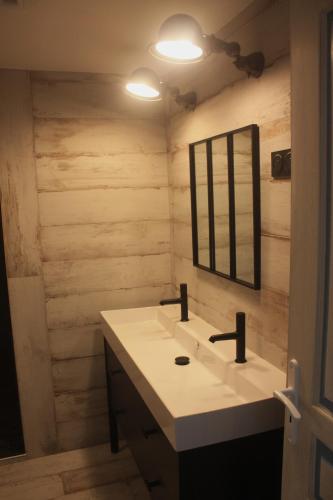 une salle de bain avec un lavabo et un miroir dans l'établissement Le Moulin du Guer, à Guerlédan