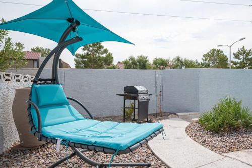 a blue chair with an umbrella on a patio at Poolside Paradise on the Strip in Las Vegas
