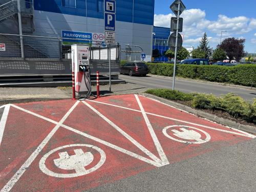 a red road with a gas pump in front of a building at Elysian apartment 1 in Trenčín