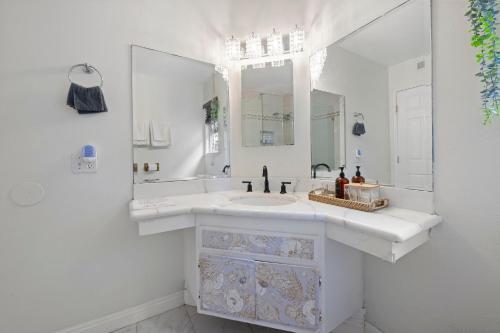 a white bathroom with a sink and a mirror at 100% Private, KingBed- SouthCoast/Newport/Disney in Costa Mesa