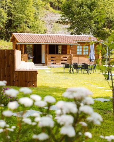 a log cabin with a table and chairs in the yard at Ohana Gerês House in Ruivãis