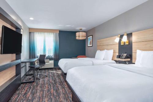 a hotel room with two beds and a flat screen tv at La Quinta by Wyndham Woodway - Waco South in Waco