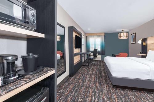 a hotel room with a bed and a kitchen at La Quinta by Wyndham Woodway - Waco South in Waco