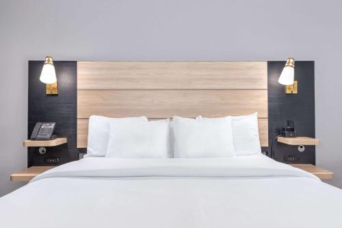 a bedroom with a large white bed with two lights at La Quinta by Wyndham Woodway - Waco South in Waco