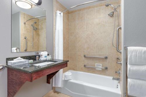 a bathroom with a tub and a sink and a shower at La Quinta by Wyndham Woodway - Waco South in Waco
