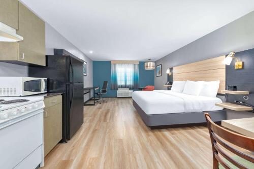 a hotel room with a bed and a kitchen at La Quinta by Wyndham Woodway - Waco South in Waco