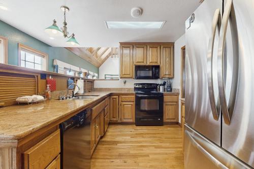a kitchen with wooden cabinets and a stainless steel refrigerator at Estate @ Vista in McKinleyville
