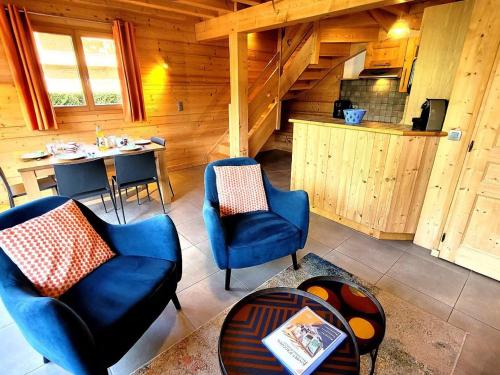 un salon avec deux chaises bleues et une table dans l'établissement Appartement duplex 3 pièces près des pistes, jardin, terrasse, Wi-Fi, parking couvert - FR-1-598-80, aux Gets
