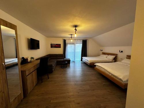 a hotel room with two beds and a couch at Pensiunea Antonia Maria in Cerna