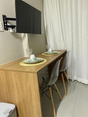 a wooden table with two chairs and a television on it at ArtStudio Open Spaces in Salvador