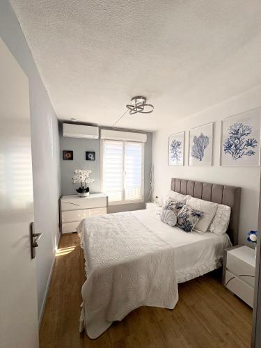une chambre avec un lit avec des draps blancs et une fenêtre dans l'établissement Appartement à la semaine, à Nice