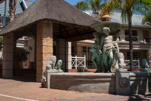 a man standing next to a fountain in front of a building at Summerview Guest Lodge in Johannesburg