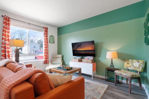 a living room with a couch and a flat screen tv at Le Nid Trailside 1BD Close to Beach Downtown in Traverse City