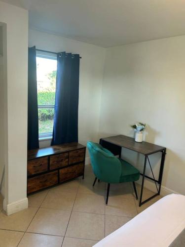 a bedroom with a desk and a green chair at Beautiful home in West Palm - 5 min to Airport in West Palm Beach