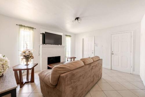 a living room with a couch and a fireplace at Beautiful home in West Palm - 5 min to Airport in West Palm Beach