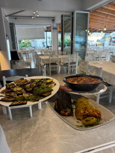 two plates of food on a table in a restaurant at Vila Spiro in Ksamil