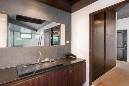 a kitchen with a sink and a mirror at The Sunhouse at Paradise Village in Ban Bang Po