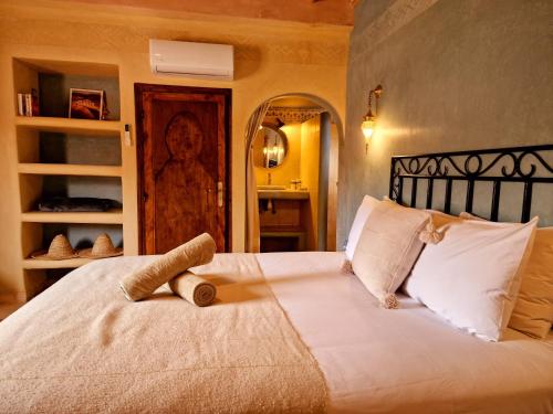 a bedroom with a large white bed with white pillows at Maison d'hôtes Tigminou - Adults Only in Aït Ben Haddou