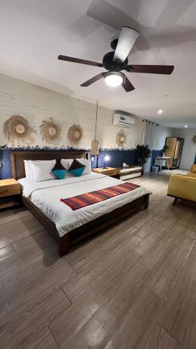 a bedroom with a large bed with a ceiling fan at Hotel Montañita in Montañita