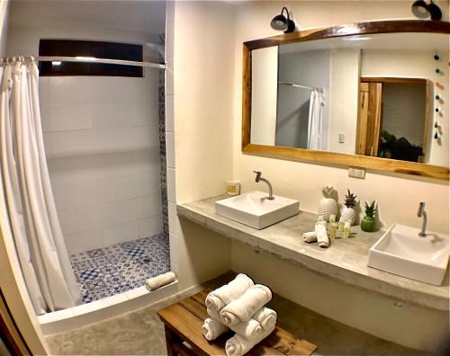 a bathroom with two sinks and a shower at Hotel Montañita in Montañita
