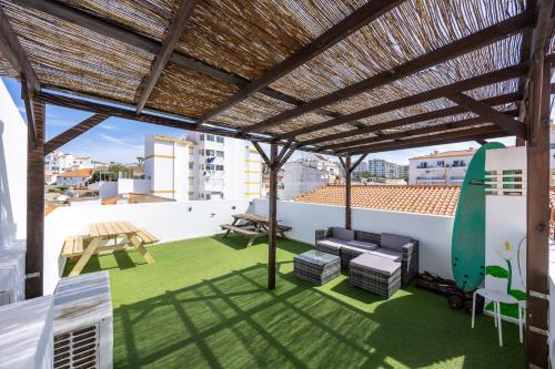 a pergola with a surfboard on the roof of a house at The 17 Party Hostel in Lagos