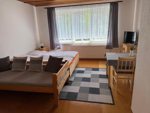 a bedroom with two beds and a table and a window at Penzion Lukeš in Vítkovice