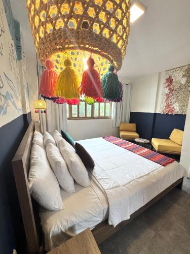 a bedroom with a large bed with a large chandelier at Hotel Montañita in Montañita