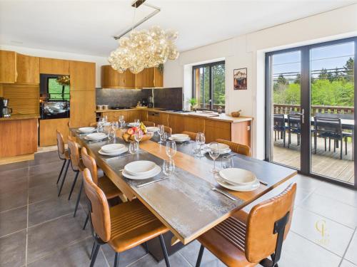 a dining room with a long table and chairs at Chalet Les Plombes - isolé, Jacuzzi, Piscine in Xonrupt-Longemer