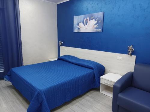 a blue bedroom with a bed and a chair at B&B Casa Dany in Ricadi