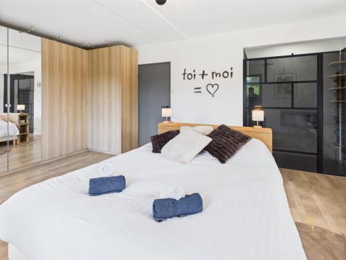 a bedroom with a large white bed with two pillows at Chalet Les Plombes - isolé, Jacuzzi, Piscine in Xonrupt-Longemer