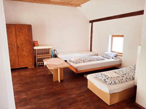 a room with two beds and a table at Vila Hedvika in Nové Hrady