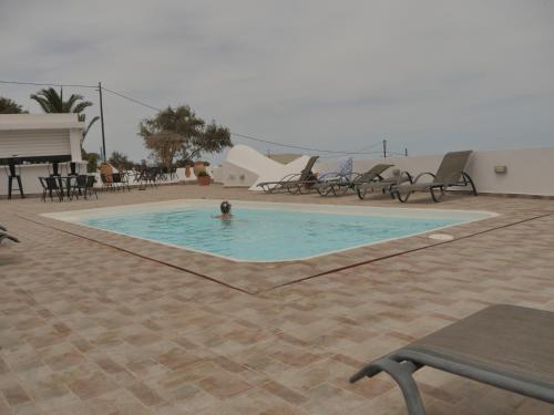 a person is swimming in a swimming pool at Ancient Thera Apartments in Kamari