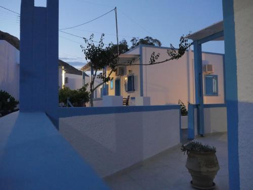 a house with a blue and white wall and a vase at Ancient Thera Apartments in Kamari
