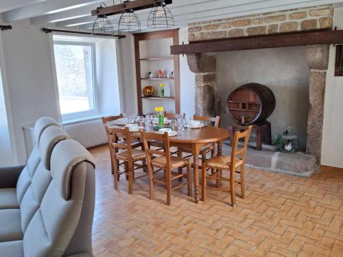 une salle à manger avec une table et une cheminée dans l'établissement Les Campanules, à Sainte-Geneviève