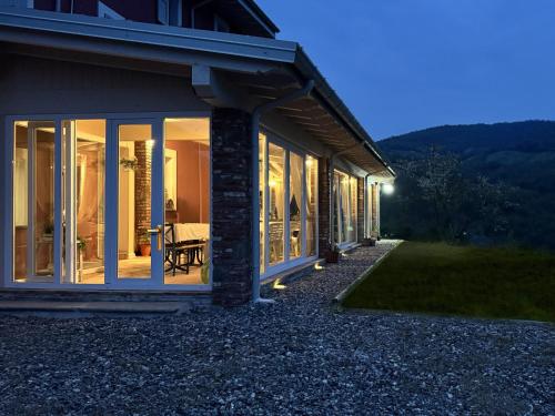 a house with large windows on the side of it at La Valle degli Amici in Pianello Val Tidone